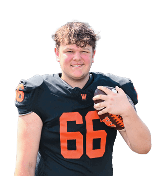 A person wearing a black football jersey with the number 66 in orange is holding a football and smiling. Description generated by AI