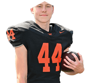 A person wearing a black football uniform with the number 44 in orange is holding a football and smiling slightly. Description generated by AI