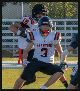 Three people wearing football uniforms and helmets are on a field with one person in a white jersey labeled “PHANTOMS" and number 3 in the center, another in a white jersey with number 18 behind, and a third in a dark jersey with number 2 facing them. Description generated by AI