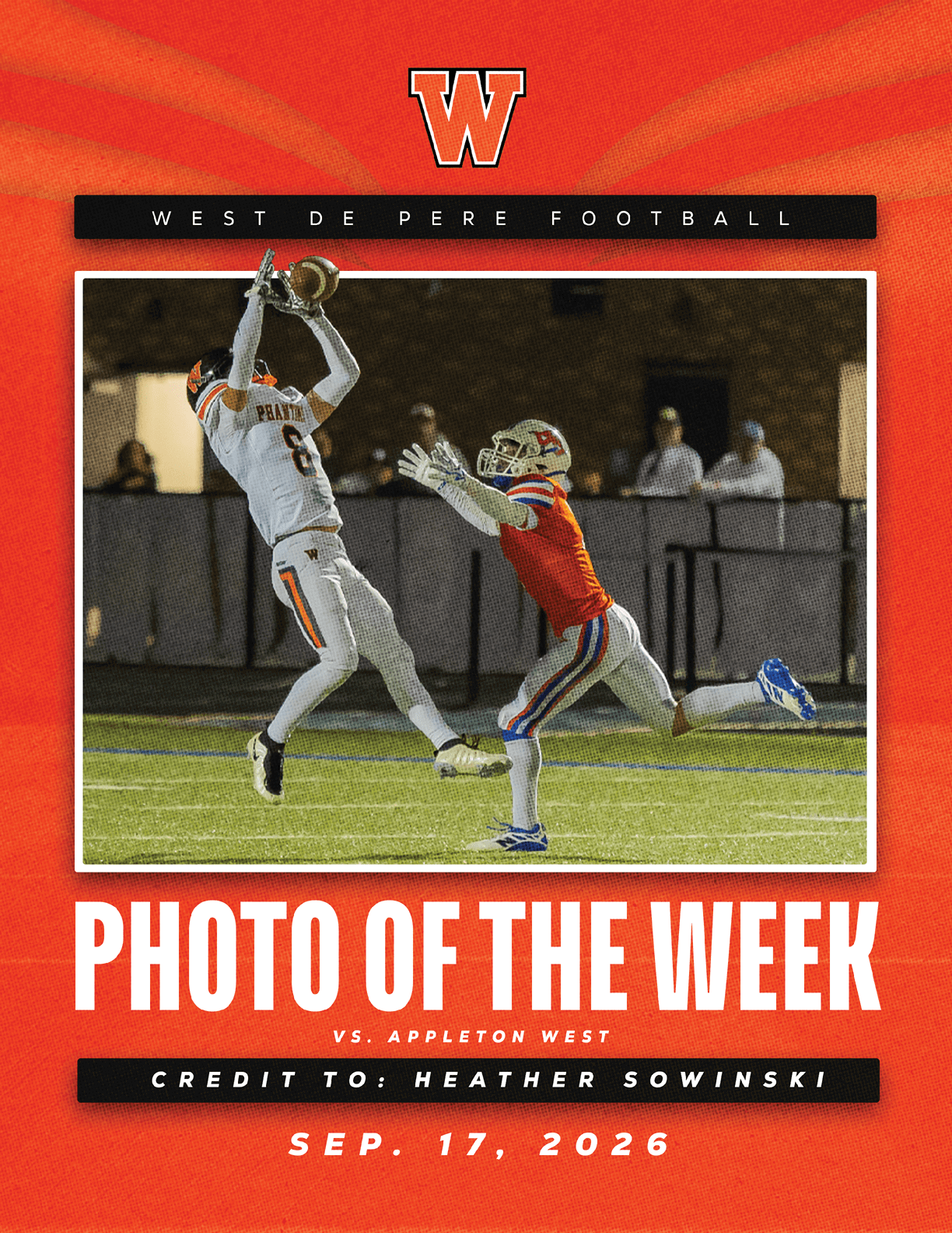 A football player in white uniform leaps to catch a ball while a player in red uniform reaches out to defend on a field during a night game. Description generated by AI