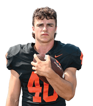 Person with curly hair wearing a black football jersey with the number 40 is holding a football close to their chest. Description generated by AI
