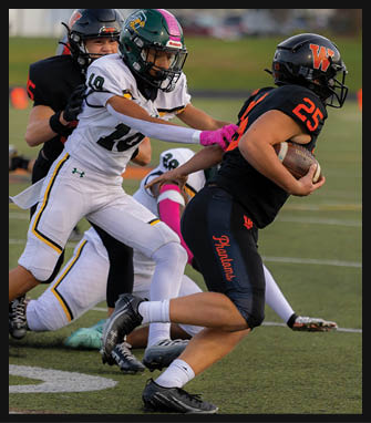 A person in a black football uniform with the number 25 is running with the ball while being tackled by a person in a white football uniform with the number 19 on a grassy field. Description generated by AI