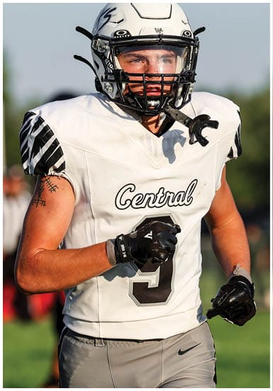 A person wearing a white football jersey with the word Central and the number 9 is running on a grassy field during a game. Descripci n generada con IA