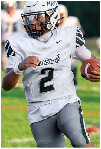 A person wearing a white football uniform with the number 2 and the word Central on the front is running on a field. Descripci n generada con IA