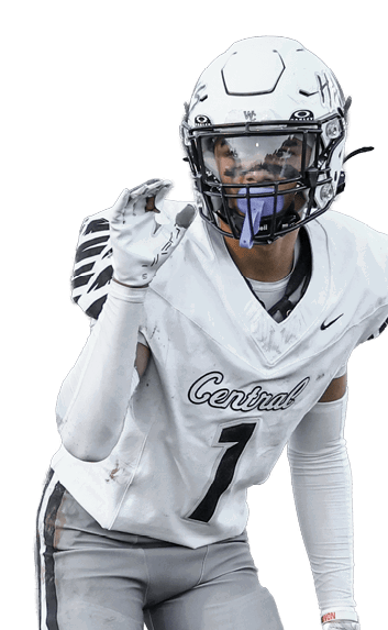 A person wearing a white football helmet, white jersey with the number 7, gray pants, and gloves is standing on grass in a ready position. Descripci n generada con IA