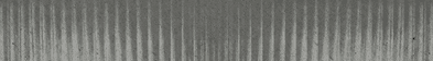 A close-up view of a textured surface with vertical ridges and a gradient of gray tones. Descripci n generada con IA
