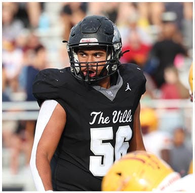 People in football uniforms from two opposing teams are positioned on a field during a game, with one team wearing black and gray and the other wearing white and yellow. Descripci n generada con IA