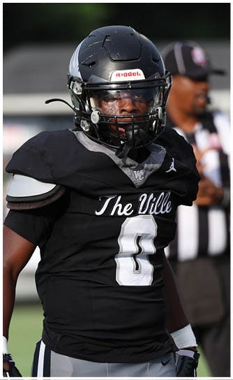 A person wearing a black football uniform with the number zero and the words The Ville stands on a field with a referee in the background. Descripci n generada con IA