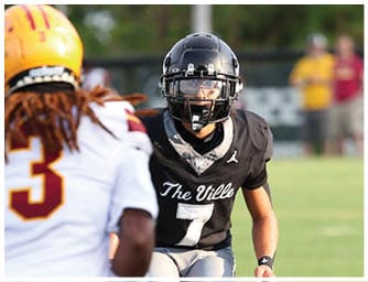 Two people in football uniforms are engaged in a game, with one wearing a black jersey labeled “The Ville" and number 7, and the other in a white jersey. Descripci n generada con IA
