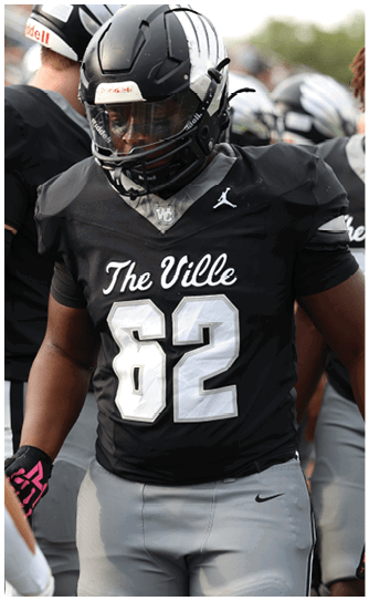 People wearing black football uniforms with “The Ville" and numbers on the front are standing on a field, with one person prominently in the center wearing number 62. Descripci n generada con IA