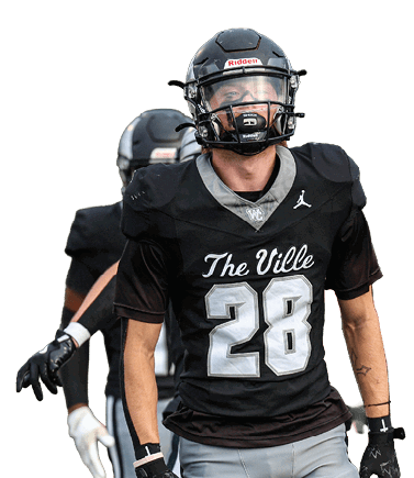 Two people wearing black football uniforms and helmets are on a field, with one person in the foreground wearing a jersey numbered 28 and the other partially visible behind. Descripci n generada con IA