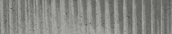 A close-up view of a textured surface with vertical ridges and a weathered, grayish appearance. Descripci n generada con IA
