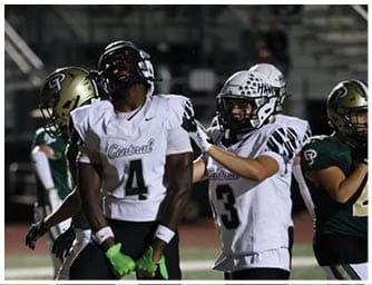 Two people in football uniforms are on a field, one wearing a white jersey with the word Central and the number 4, and the other wearing a green jersey and gold helmet with a “P" logo. Descripci n generada con IA