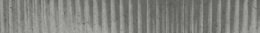 A close-up view of a textured surface with vertical ridges and a weathered, grayish appearance. Descripci n generada con IA