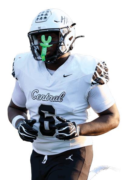 A person wearing a white football jersey and black pants is running on a green field during a game. Descripci n generada con IA