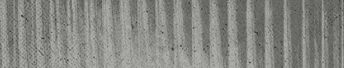 A close-up view of a textured surface with vertical ridges and a weathered, grayish appearance. Descripci n generada con IA