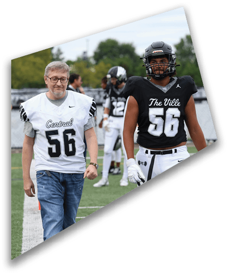 Two people wearing athletic clothing and cleats are standing on a green sports field. Descripci n generada con IA