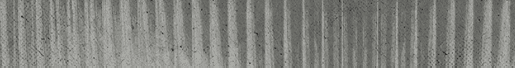 A close-up view of a textured surface with vertical ridges and a weathered, grayish appearance. Descripci n generada con IA
