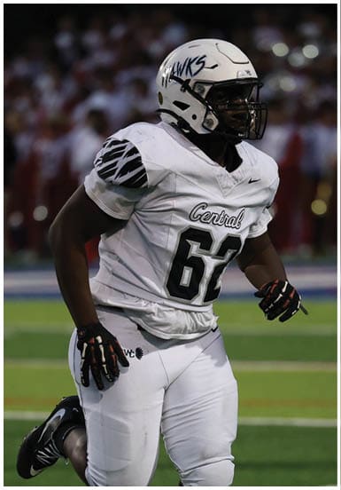 A person wearing a white football uniform with the number 62 and the word Central is running on a green field during a game. Descripci n generada con IA