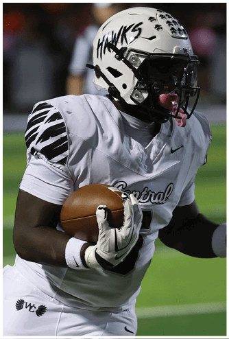 A person wearing a white football jersey and gloves is holding a football close to their chest. Descripci n generada con IA