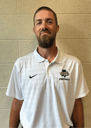 A young man wearing a white and black jersey with the number 14 on it. Description generated by AI