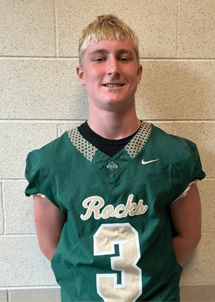 A young man wearing a white and black jersey with the number 14 on it. Description generated by AI