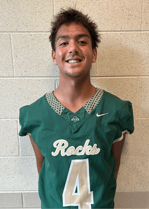 A young man wearing a white and black jersey with the number 14 on it. Description generated by AI