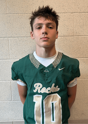 A young man wearing a white and black jersey with the number 14 on it. Description generated by AI