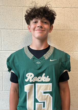 A young man wearing a white and black jersey with the number 14 on it. Description generated by AI