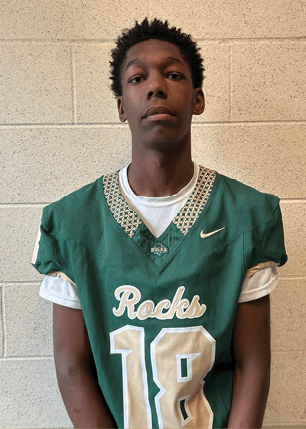 A young man wearing a white and black jersey with the number 14 on it. Description generated by AI