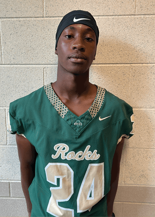 A young man wearing a white and black jersey with the number 14 on it. Description generated by AI