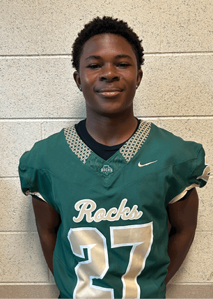 A young man wearing a white and black jersey with the number 14 on it. Description generated by AI