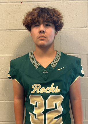 A young man wearing a white and black jersey with the number 14 on it. Description generated by AI