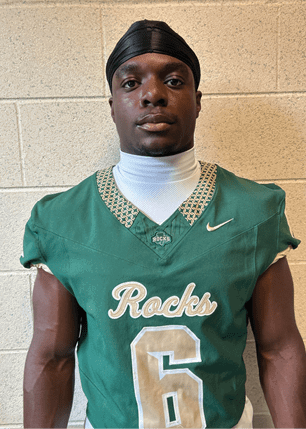 A young man wearing a white and black jersey with the number 14 on it. Description generated by AI
