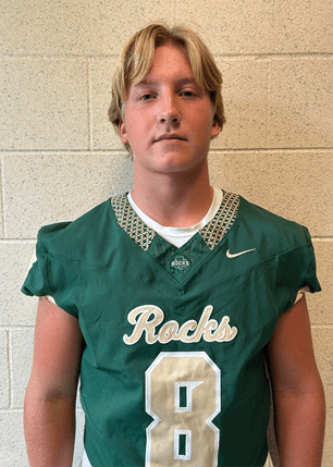 A young man wearing a white and black jersey with the number 14 on it. Description generated by AI
