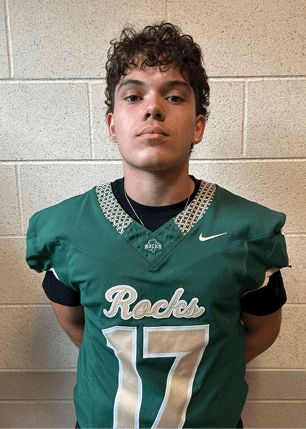 A young man wearing a white and black jersey with the number 14 on it. Description generated by AI