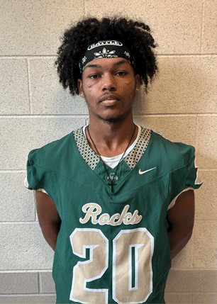 A young man wearing a white and black jersey with the number 14 on it. Description generated by AI
