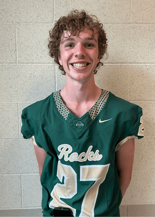 A young man wearing a white and black jersey with the number 14 on it. Description generated by AI