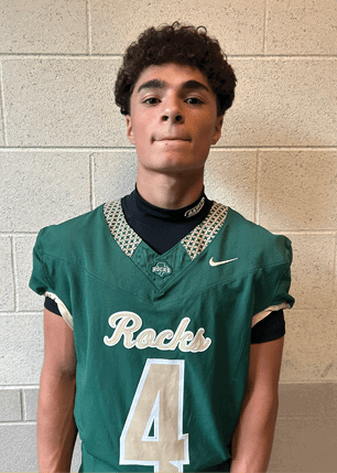 A young man wearing a white and black jersey with the number 14 on it. Description generated by AI