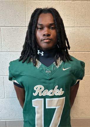 A young man wearing a white and black jersey with the number 14 on it. Description generated by AI