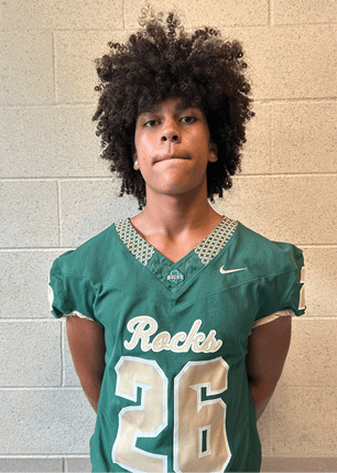 A young man wearing a white and black jersey with the number 14 on it. Description generated by AI
