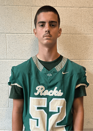 A young man wearing a white and black jersey with the number 14 on it. Description generated by AI