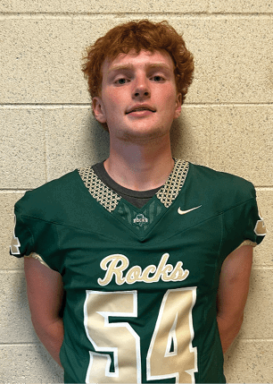 A young man wearing a white and black jersey with the number 14 on it. Description generated by AI