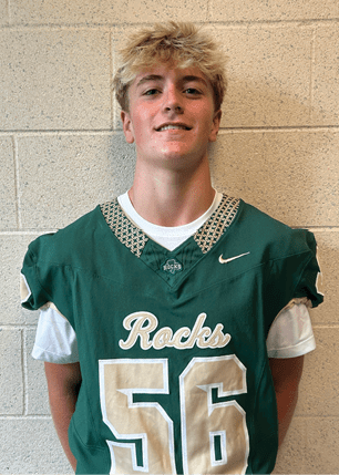 A young man wearing a white and black jersey with the number 14 on it. Description generated by AI