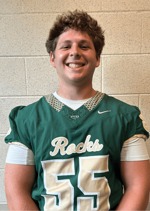 A young man wearing a white and black jersey with the number 14 on it. Description generated by AI