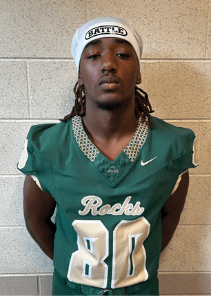 A young man wearing a white and black jersey with the number 14 on it. Description generated by AI