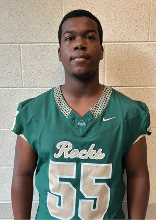 A young man wearing a white and black jersey with the number 14 on it. Description generated by AI