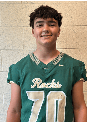 A young man wearing a white and black jersey with the number 14 on it. Description generated by AI
