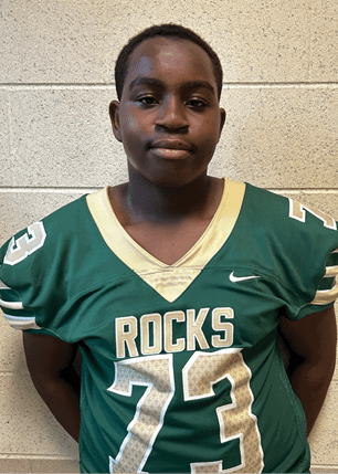 A young man wearing a white and black jersey with the number 14 on it. Description generated by AI