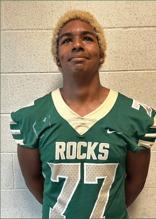 A young man wearing a white and black jersey with the number 14 on it. Description generated by AI